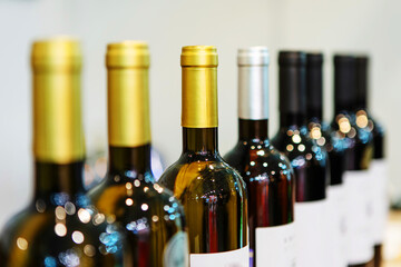 Bottles with white and red wine. Production and trade of alcoholic beverages from grapes. Selective focus. Close-up