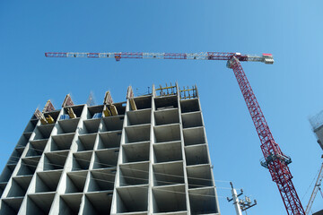 building construction site with tower crane on clear blue sky background