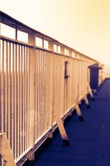Handrails on the promenade deck of a large cruise ship in warm sunset lighting. blurred out background.