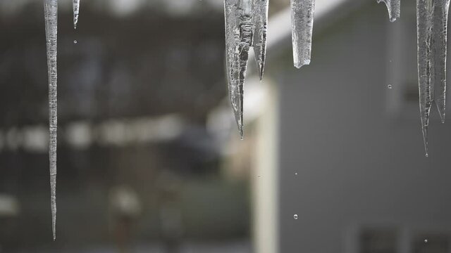 Drops during the thaw. Spring melting of icicles on the roof of the house. The arrival of spring. Change of seasons from winter to spring. FulHD video footage slow motion 100 fps.