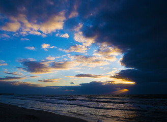 Fototapeta premium sunset on the beach with stormy sky.