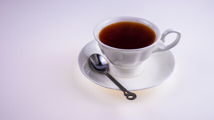 white cup of tea with iron spoon on white background, isolate