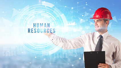 Handsome businessman with helmet drawing HUMAN RESOURCES inscription, contruction business concept