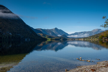 Autumn morning with patches of fog on the lake Grundlsee, Styria, Austria.