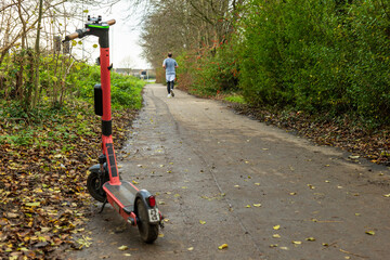 Battery powered electric scooter vehicle left on pedestrian footpath in england uk