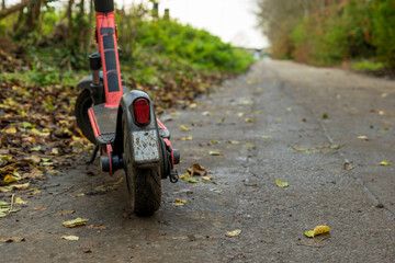 Battery powered electric scooter vehicle left on pedestrian footpath in england uk