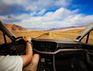 the driver's hands on the steering wheel inside the car, traveling in a car on a country road in...
