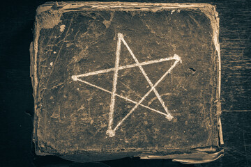 Old and big book with a pentagram symbol