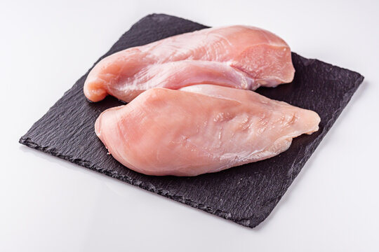 raw chicken fillet on a white acrylic background