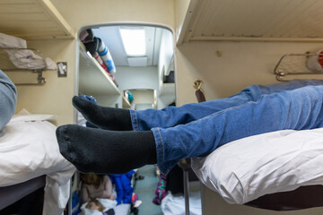Male legs in black socks in the aisle of a train car