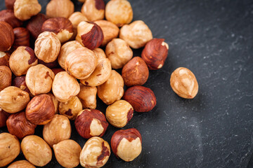fresh natural hazelnuts on a dark stone background