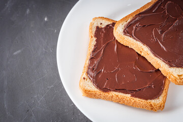 toasts with chocolate butter on a dark stone background