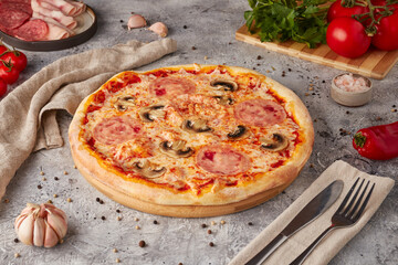 Pizza with slices, sauce and herbs, textured background