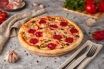 Pizza with slices, sauce and herbs, textured background