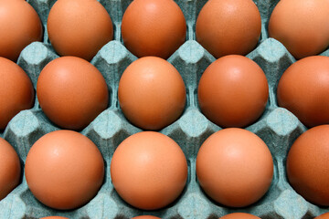 Close-up of red eggs in a cardboard box.
