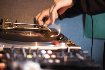 close up of dj hands working on his vinyl turntables 