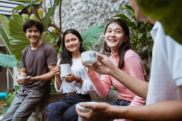 group of friends relax and drink together in the garden
