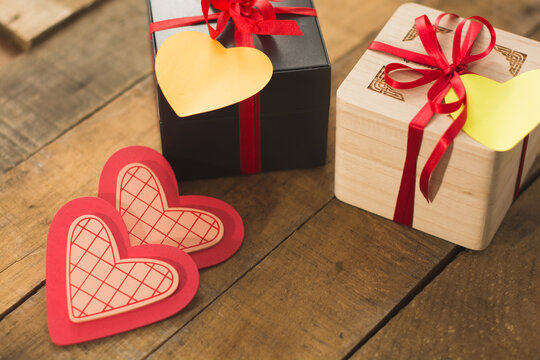Image of Valentine's day, symbols of love, gift boxes on a background of wooden planks.