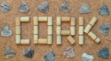Cork sign with birch bark hearts on the cork table. Wine corks on cork background. Handmade letters...