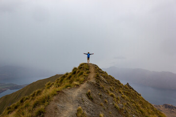 A manlooking at the beautiful landscape of the mountains and Lake Wanaka. Roys Peak Track, South Island, New Zealand