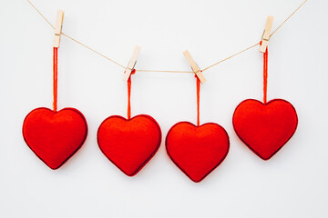red hearts on a wooden background. Red Valentine hearts hang with wooden clips on a natural string...