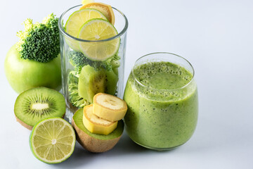 Glass of Fresh Green Smoothie with Kiwi Broccoli Green Apples and Babanas Healthy Detox Drink Blue Background