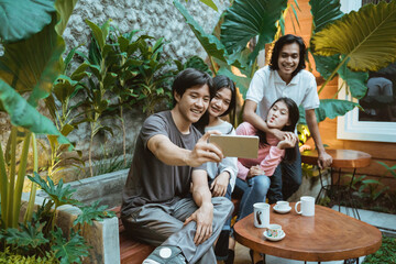 Group of young people taking a selfie outdoors, having fun