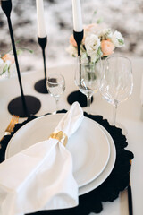 decoration of a wedding table, table setting for a wedding, white dishes on a wedding table with elements of gold leaves, themed decor