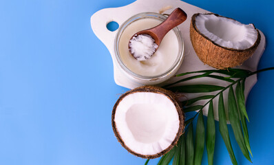Coconut oil on a blue background.
Flat lei.Copy space.