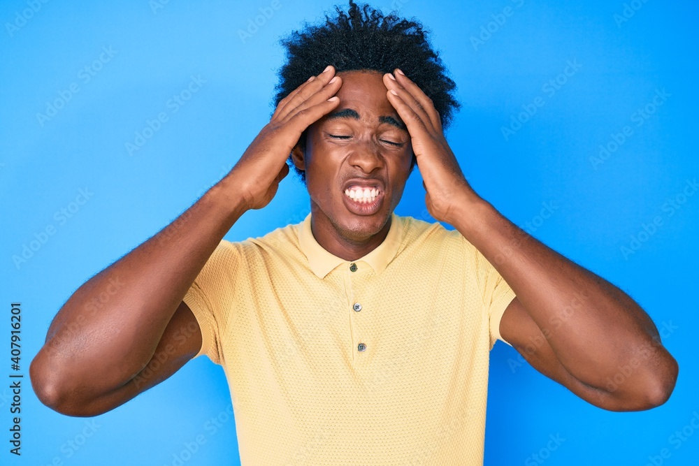 Poster Handsome african american man with afro hair wearing casual clothes with hand on head, headache because stress. suffering migraine.