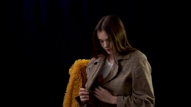 Female model photoshoot wearing vintage jacket sitting on fur covered chair striking poses for the camera flashes