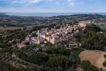 Fototapeta na wymiar Italy - aerial view of the medieval village of Gradara in the province of Pesaro and Urbino in the Marche region. In the background the Romagna Riviera and the Adriatic Sea