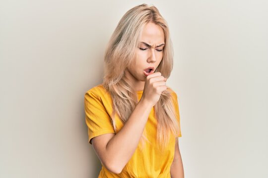 Beautiful caucasian blonde girl wearing casual tshirt feeling unwell and coughing as symptom for cold or bronchitis. health care concept.