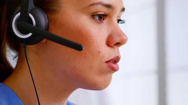 Close up of medical operator with headphone consulting patients during telehealth discussion in hospital. Healthcare physician in medicine uniform, doctor nurse assistent helping with appointment