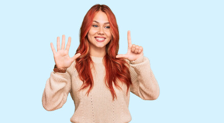 Young redhead woman wearing casual winter sweater showing and pointing up with fingers number seven while smiling confident and happy.