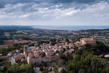 Fototapeta na wymiar Italy - aerial view of the medieval village of Gradara in the province of Pesaro and Urbino in the Marche region. In the background the Romagna Riviera and the Adriatic Sea