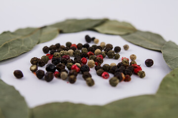 bay leaf with peppercorns on a white background