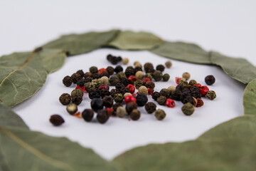 bay leaf with peppercorns on a white background