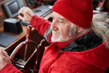 Yacht skipper standing at the steering wheel