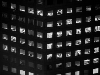 monochrome picture of illuminated windows of a tall office building at night