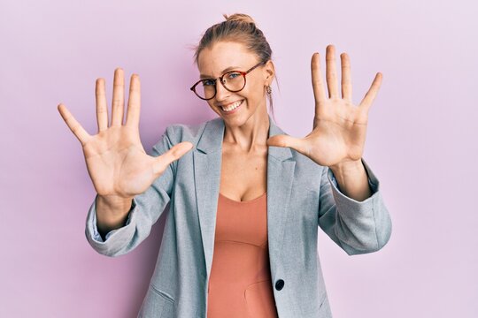 Beautiful caucasian woman wearing business jacket and glasses showing and pointing up with fingers number ten while smiling confident and happy.