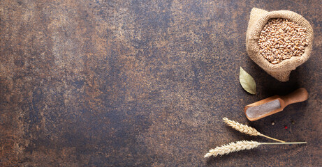 Bakery ingredients for homemade bread baking on table. Wheat grain food in bag, top view at stone...