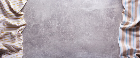 Folded tablecloth at stone or marble surface of table. Panorama of cloth napkin texture background