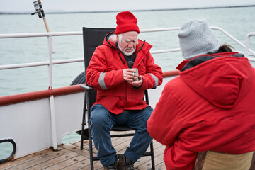 Fishermans discussing work at the boat while drinking tea