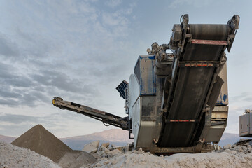 Mechanical conveyor belt to pulverize rock and stone and generate gravel