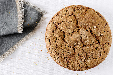 Round bread loaf and tea towel top view. Homemade bread making.