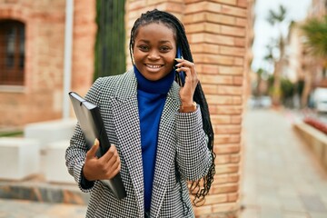 Young african american businesswoman smiling happy talking on the smartphone at the city.