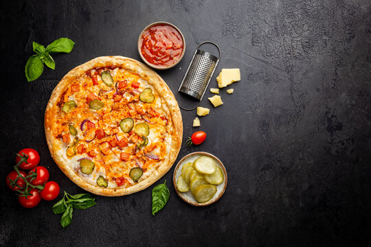 Tasty Cheeseburger Pizza And Cooking Ingredients Tomatoes And Basil On Dark Background. Top View