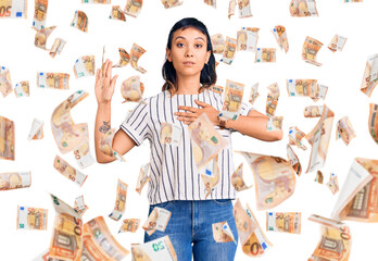 Young woman wearing casual clothes swearing with hand on chest and open palm, making a loyalty...