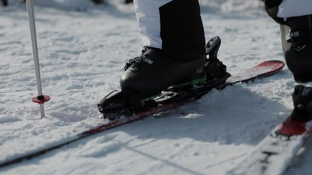 Close-up view of Skier Stepping into Ski Bindings on the Mountain.